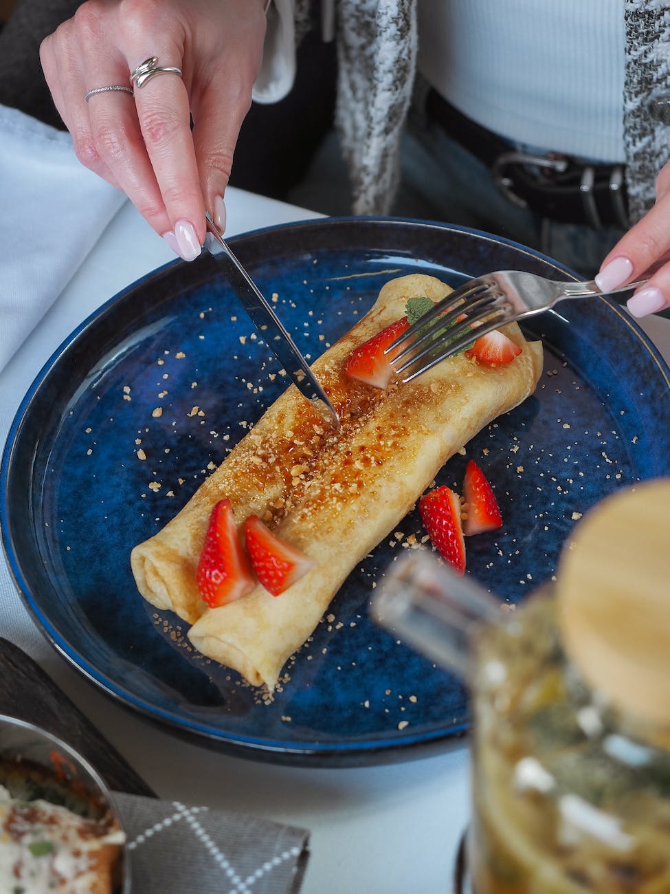 woman eating crepes with strawberries